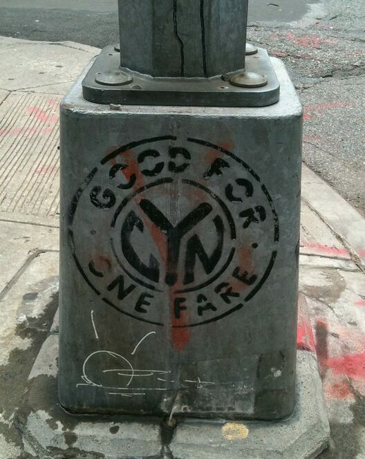 Image of NYC lamppost base on which is printed "Good for One Fare"