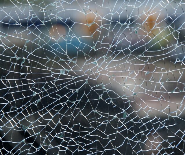 Abstract photograph of a wet spider web that looks like broken glass.