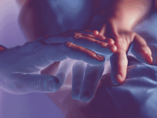 Image of hands touching, with purple-light rayogram filter applied