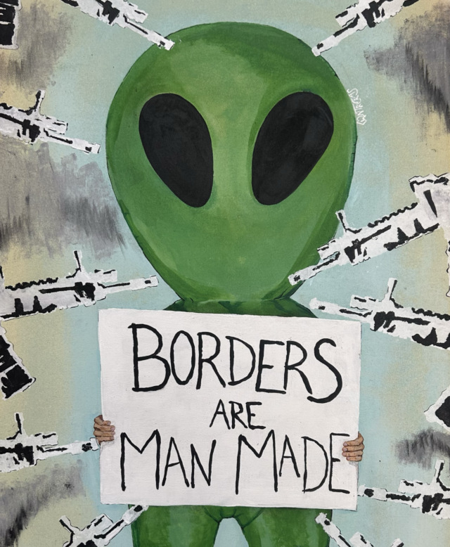 Image of green alien holding a sign saying "Borders are Man Made," surrounded by the barrels of guns.